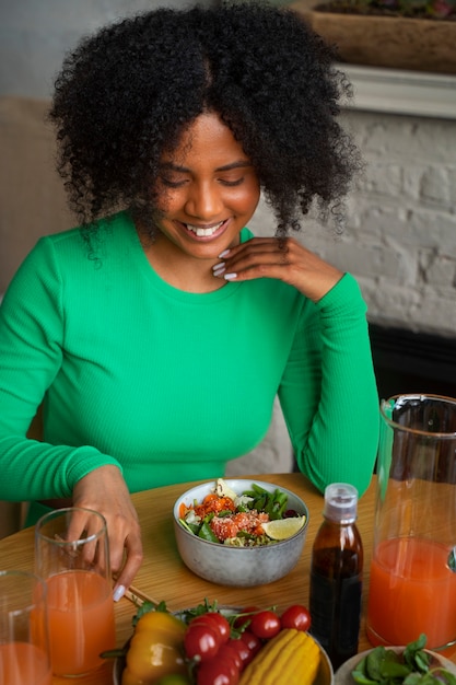 Mujer de tiro medio comiendo tazón de salmón