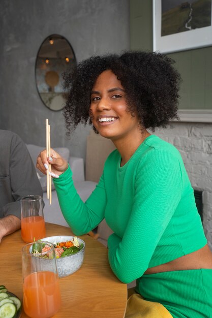 Mujer de tiro medio comiendo tazón de salmón