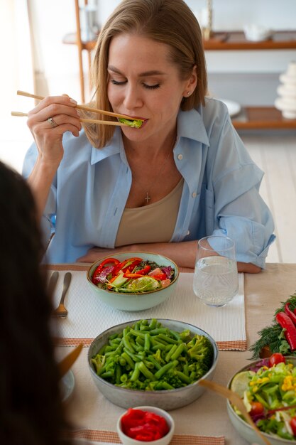 Mujer de tiro medio comiendo tazón de salmón