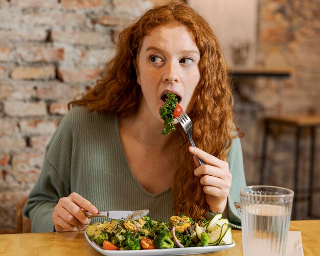 Mujer de tiro medio comiendo