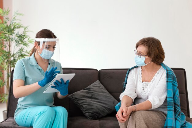 Mujer de tiro medio comprobando al paciente