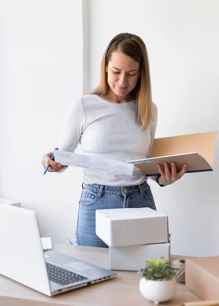 Mujer de tiro medio comprobando la factura