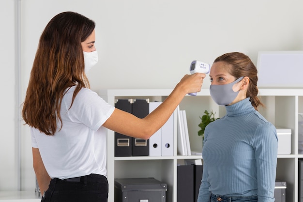 Mujer de tiro medio comprobando la temperatura