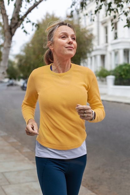 Mujer de tiro medio corriendo al aire libre