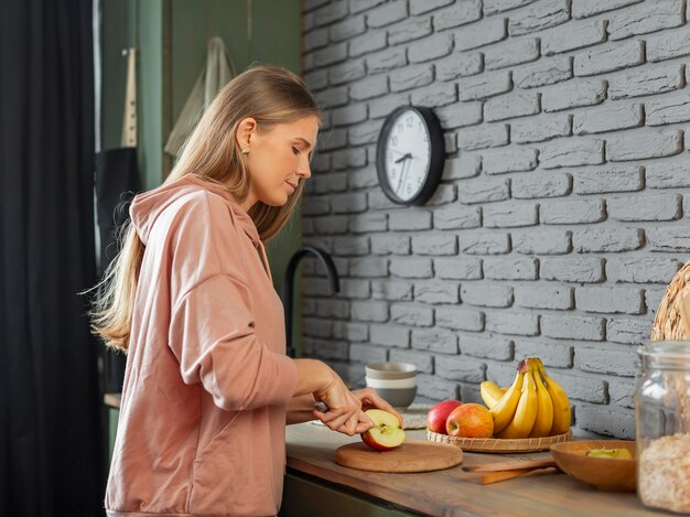 Mujer de tiro medio cortando manzana