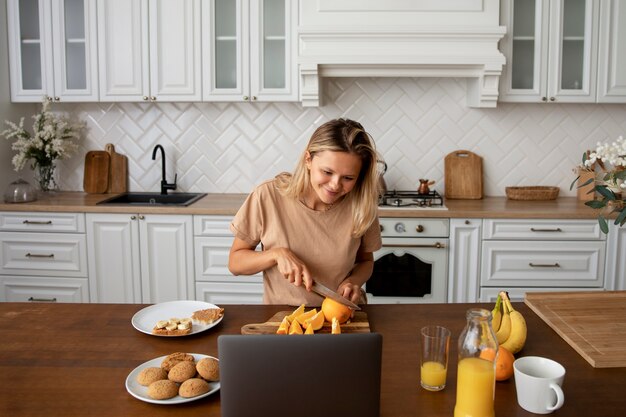 Foto gratuita mujer de tiro medio cortando naranja