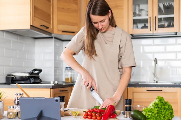 Mujer de tiro medio cortando verduras