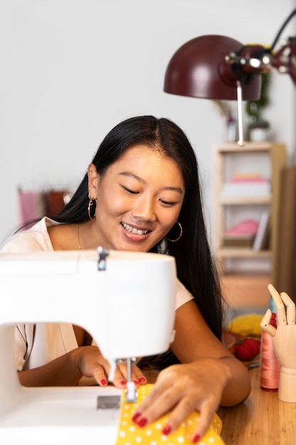 Foto gratuita mujer de tiro medio coser con máquina