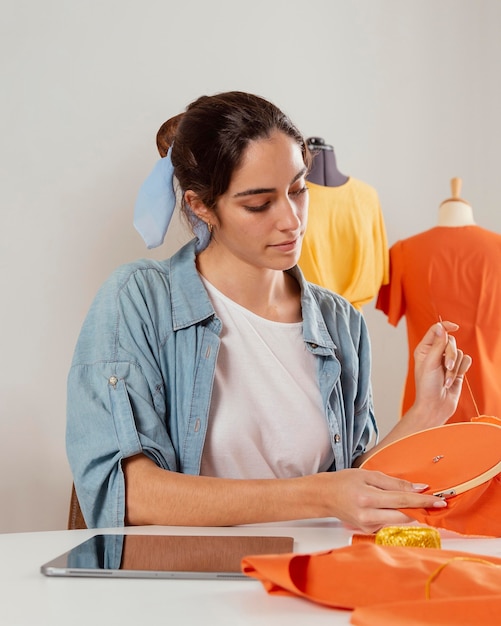 Mujer de tiro medio cosiendo