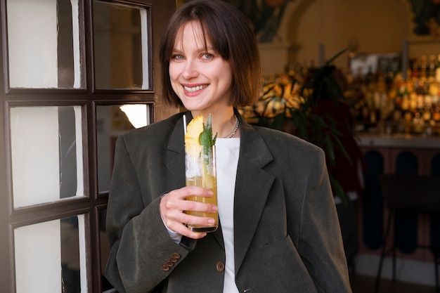 Mujer de tiro medio con delicioso cóctel.