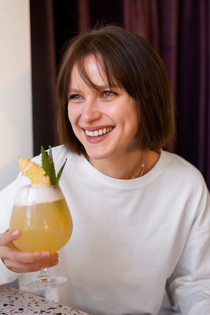 Mujer de tiro medio con delicioso cóctel.