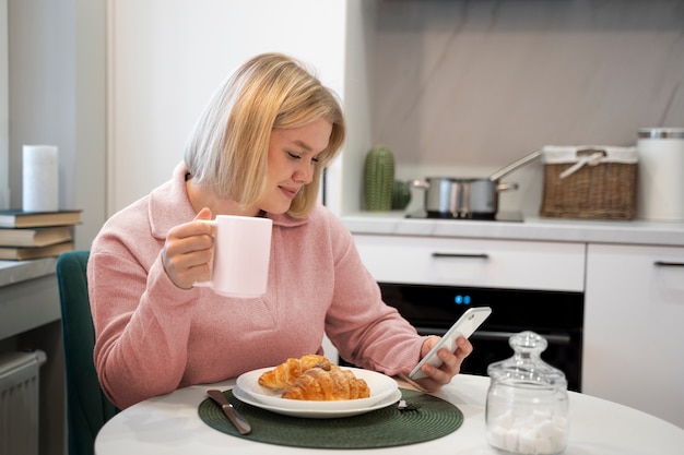 Mujer de tiro medio desayunando