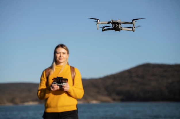 Foto gratuita mujer de tiro medio con drone al aire libre