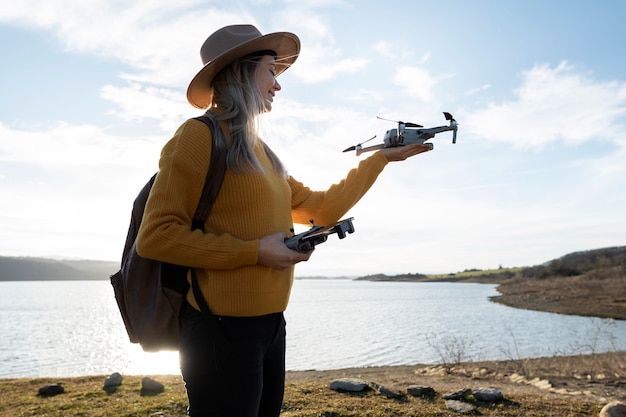 Mujer de tiro medio con drone al aire libre