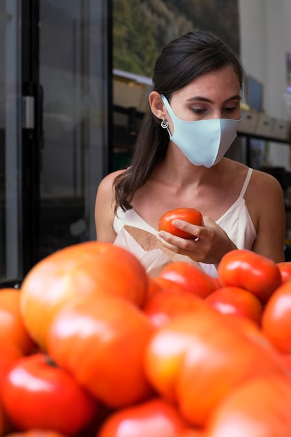 Foto gratuita mujer de tiro medio echando un vistazo a los tomates