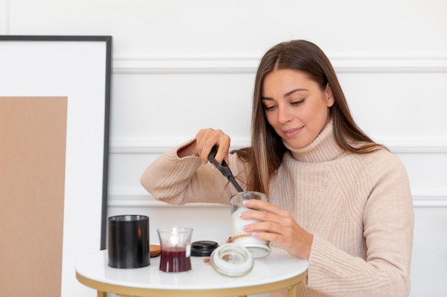 Mujer de tiro medio encendiendo velas