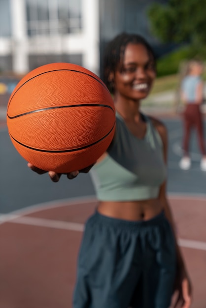 Mujer de tiro medio entrenando para baloncesto.