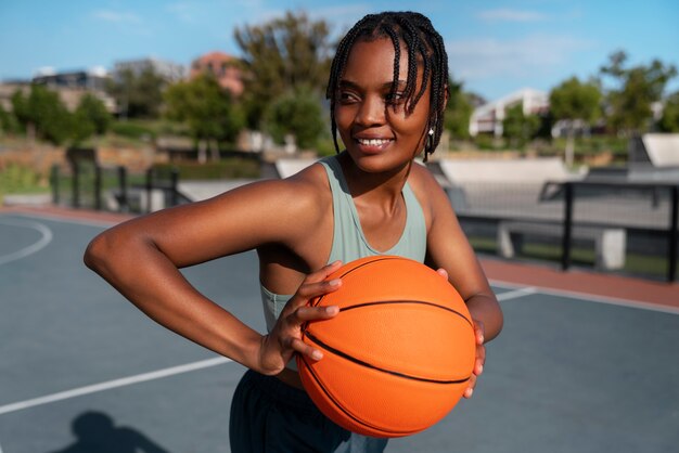 Mujer de tiro medio entrenando para baloncesto.