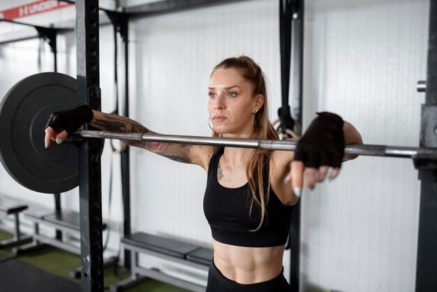 Mujer de tiro medio entrenando con barra