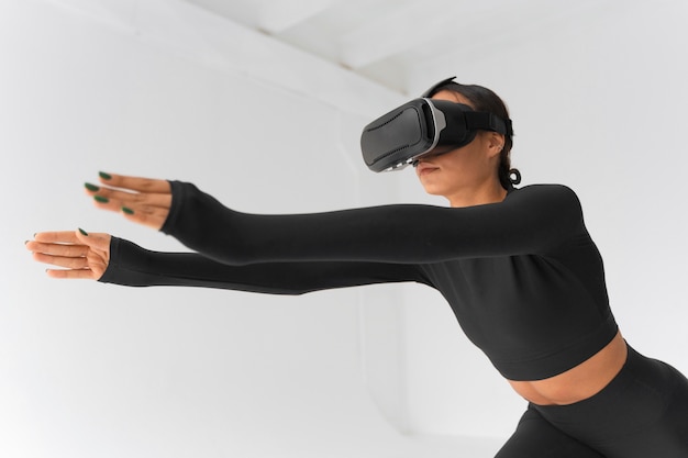 Foto gratuita mujer de tiro medio entrenando con gafas vr puestas