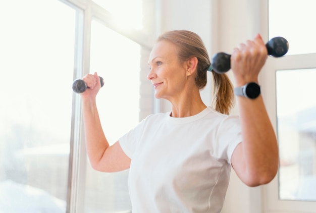 Mujer de tiro medio entrenando en interiores