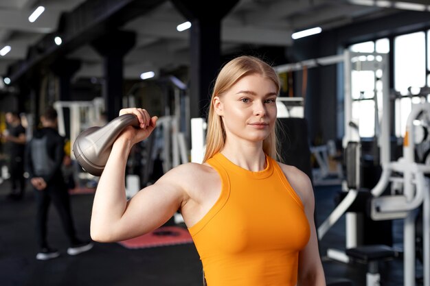 Mujer de tiro medio entrenando con pesas rusas