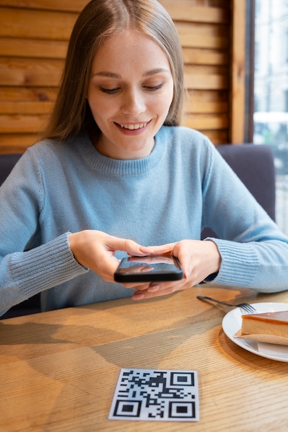 Mujer de tiro medio escaneando código qr