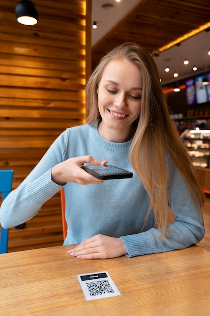 Mujer de tiro medio escaneando qr