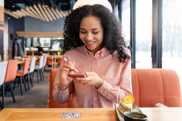 Mujer de tiro medio escaneando qr