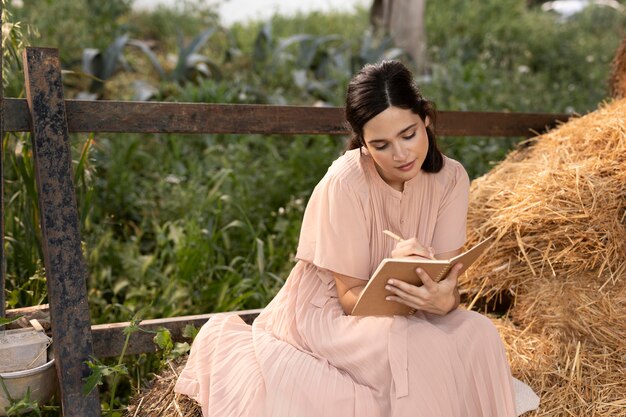 Mujer de tiro medio escribiendo al aire libre