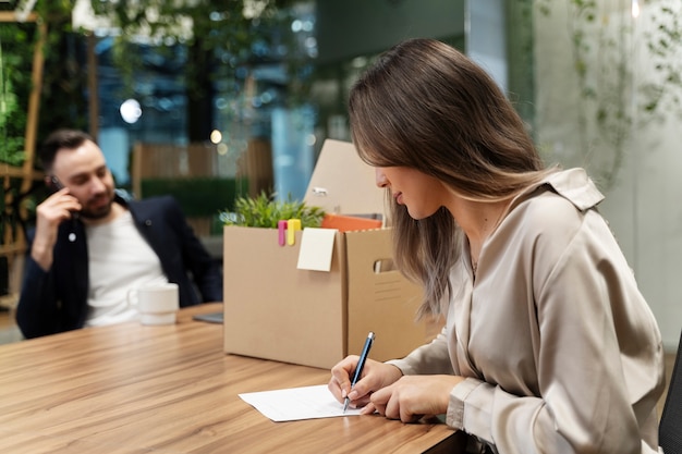 Mujer de tiro medio escribiendo carta de renuncia