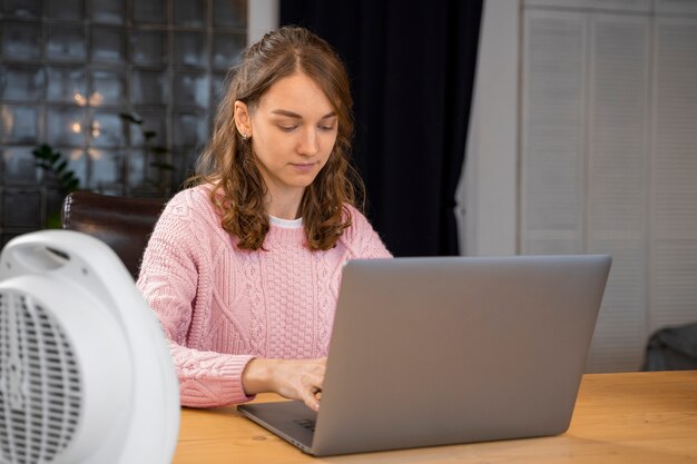 Mujer de tiro medio escribiendo en la computadora portátil
