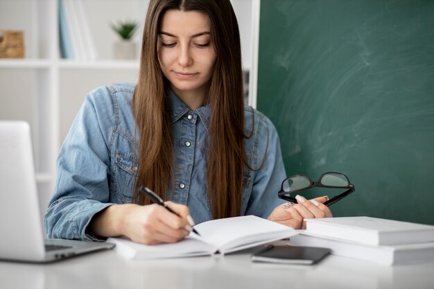 Mujer de tiro medio escribiendo en el cuaderno