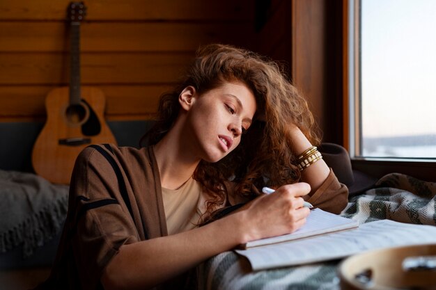 Mujer de tiro medio escribiendo música