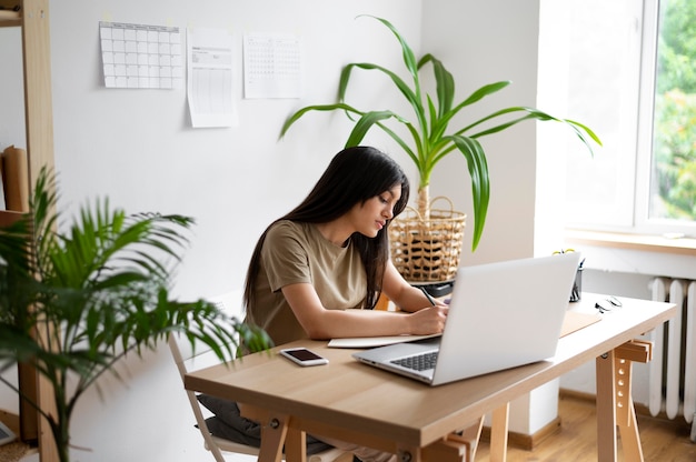 Mujer de tiro medio escribiendo notas