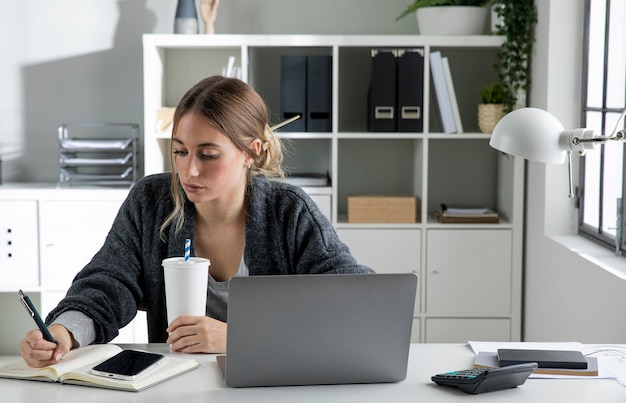 Foto gratuita mujer de tiro medio escribiendo en un portátil