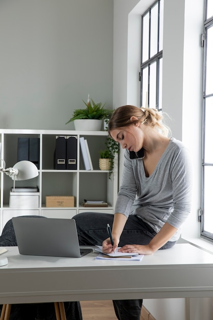 Foto gratuita mujer de tiro medio escribiendo en un portátil