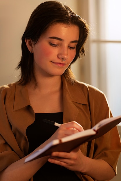 Mujer de tiro medio escribiendo en su diario