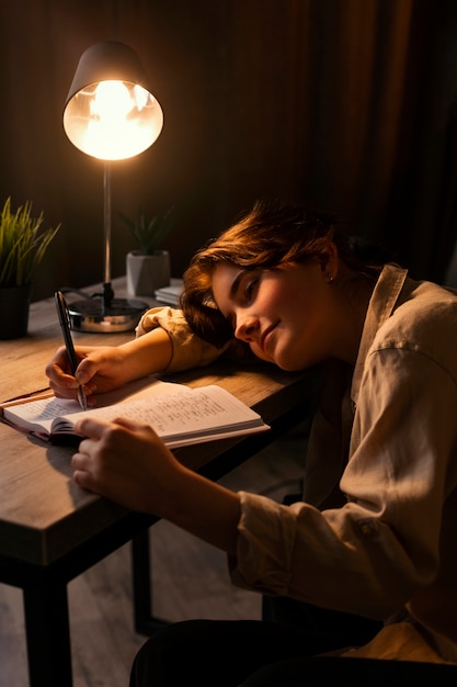 Foto gratuita mujer de tiro medio escribiendo en su diario