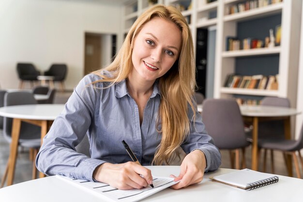 Mujer de tiro medio escribiendo