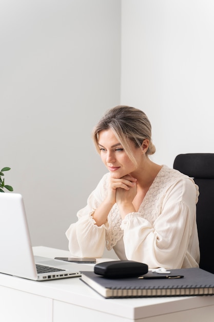 Mujer de tiro medio en el escritorio