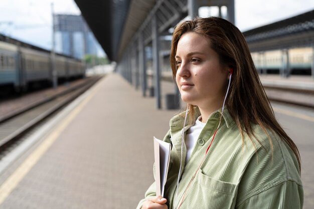 Mujer de tiro medio esperando el tren