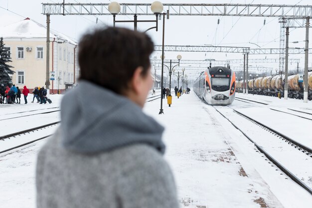 Mujer de tiro medio esperando el tren