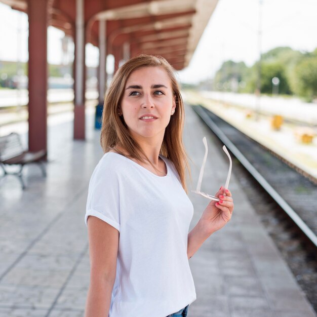 Mujer de tiro medio en la estación de tren