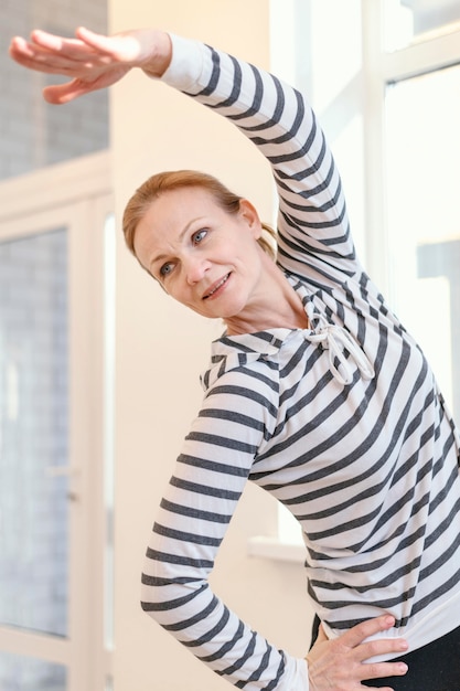 Foto gratuita mujer de tiro medio estirando en el interior