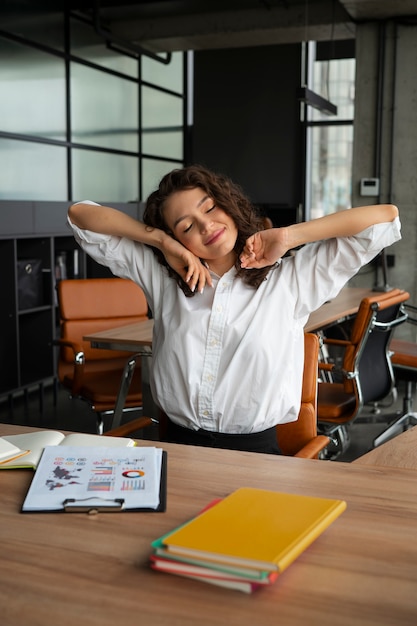 Mujer de tiro medio estirando en el trabajo