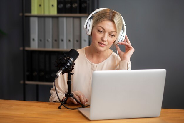 Mujer de tiro medio grabando podcast en interiores