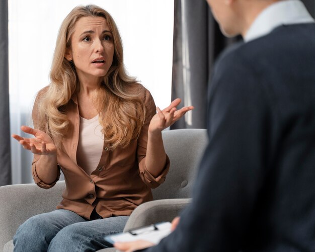 Mujer de tiro medio hablando con consejero de hombre