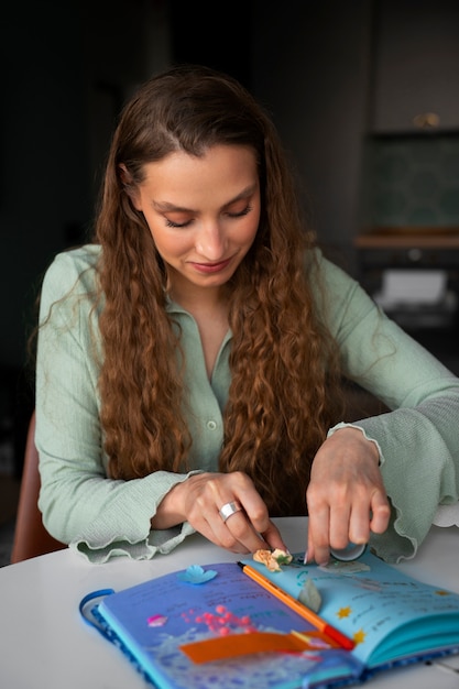 Mujer de tiro medio haciendo un diario creativo