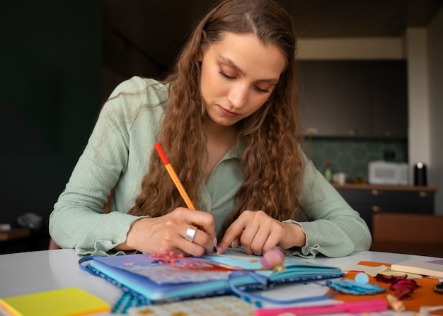 Mujer de tiro medio haciendo un diario creativo